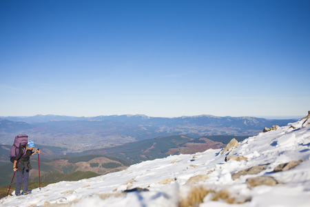 The girl with the backpack goes to the mountain top.の写真素材