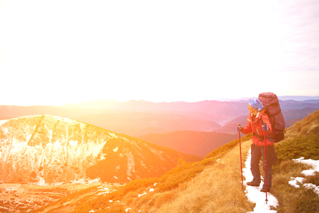 The girl with the backpack resting on a mountain trail.の写真素材