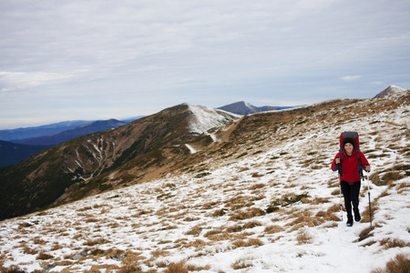The girl with the backpack goes on a mountain trail.の写真素材