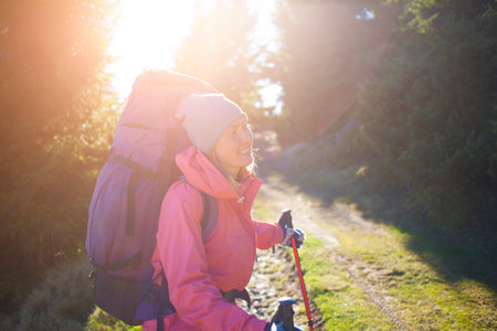 Young girl with backpack posing in nature on a Sunny day.