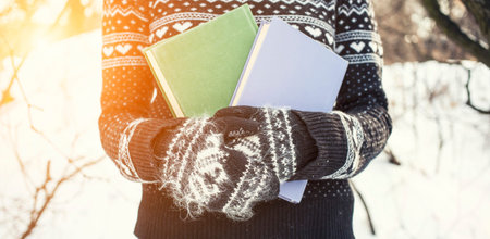 Girl in a wool sweater holding an old book.