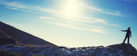 Silhouette climbers on the top of a high mountain.の写真素材