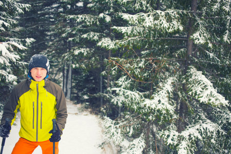 Portrait of a young man in a winter forest with a vintage filter.