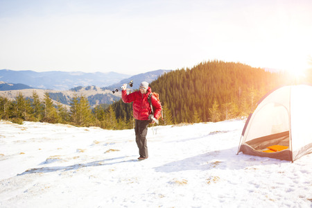 Climber with a backpack near the tent packing.の写真素材