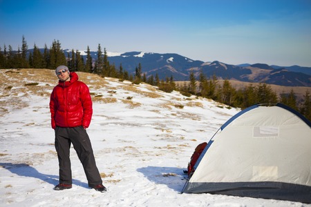 Climber with a backpack near the tent packing.の写真素材