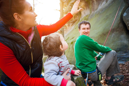 Young family outdoors is climbing on the rocks during the holidays.の写真素材