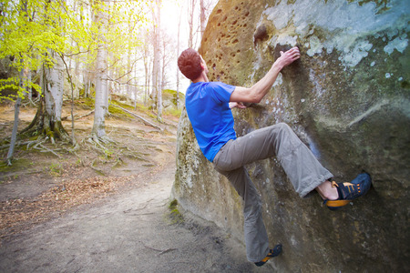 Climber is bouldering on the rocks in the forest.の写真素材