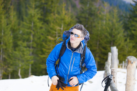 The climber wears a backpack before climbing into the mountains in the snow.の写真素材