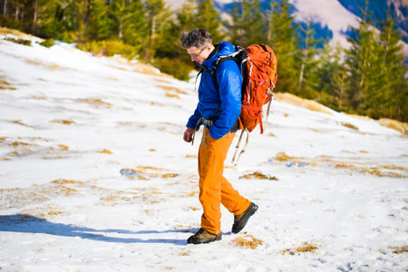Portrait of climber on a background of mountains on a winter day.