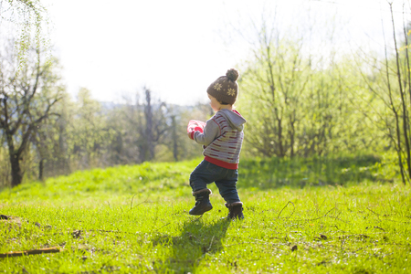 A small child plays with a Frisbee outdoors in the woods.の写真素材