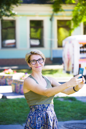 Portrait of beautiful girl with blond hair with the phone in his hand.の写真素材