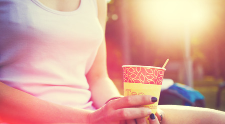 Girl drinking coffee sitting on the street in the Park.の写真素材