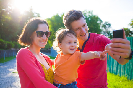 Young and happy family with a baby taking a selfie.の写真素材