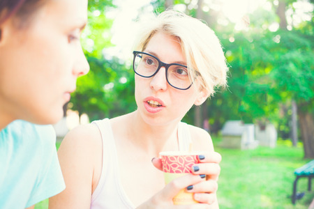 Girls having fun in the Park and drink coffee.の写真素材