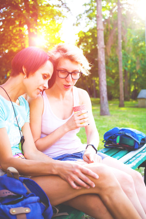 Girls having fun in the Park and drink coffee.の写真素材