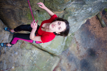 Girl rock climber climbs difficult route on the cliffs.の写真素材