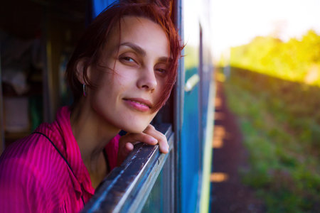 Beautiful girl looks out of the train window during the trip.