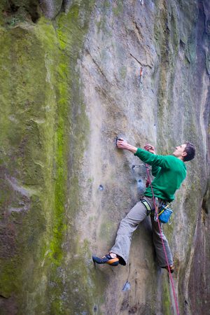 Male rock climber climbs up the mountain.の写真素材