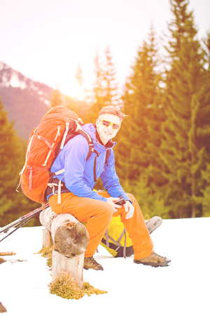 Hiker with backpack resting on a halt and to use the phone.の写真素材