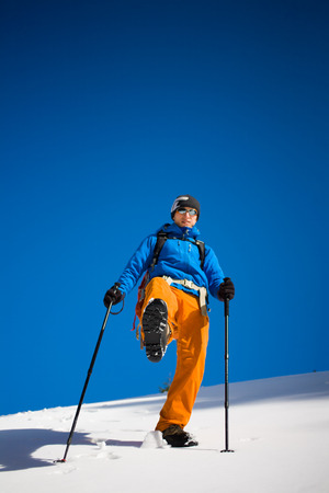 The climber is on a snowy hill during a winter hike.の写真素材