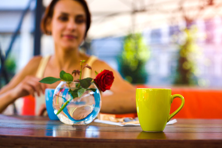 Mug with a hot drink is on a wooden table in summer cafe.
の写真素材