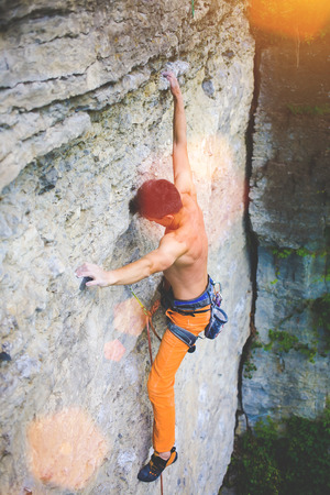 athletic man climbing the mountains, playing sports in nature.の写真素材