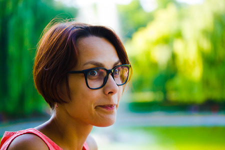Portrait of a girl with dark hair in stylish glasses in daylight.の写真素材
