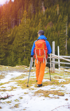 Hiker with backpack goes on the track. Journey through the winter mountains.の写真素材