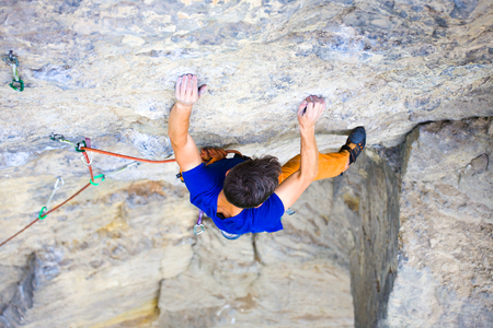 athletic man climbing the mountains, playing sports in nature.の写真素材