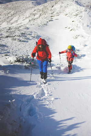 two girls are traveling with a dog in the mountains in winter, the snowy mountains during the winter holidays and mountaineering.
の写真素材