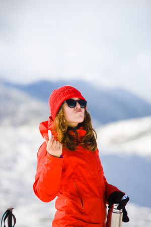 girl climber uses chapstick in the mountains in winter, hygiene during the winter holidays in the mountains.の写真素材