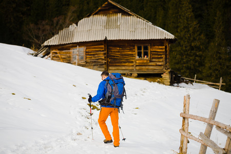 Climber with backpack and walking sticks is the snowy slope.の写真素材