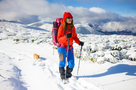 girl with dog walking on the trail in the mountains, winter in the mountains.の写真素材