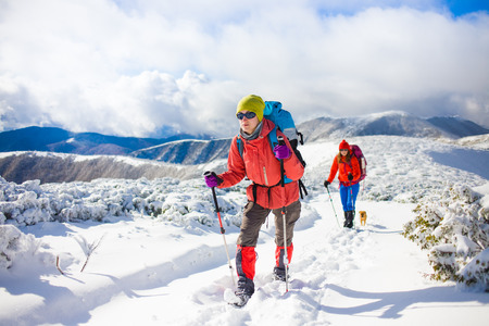two girls are traveling with a dog in the mountains in winter, the snowy mountains during the winter holidays and mountaineering.
の写真素材