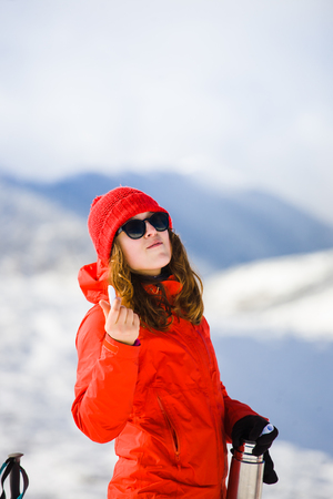 girl climber uses chapstick in the mountains in winter, hygiene during the winter holidays in the mountains.の写真素材