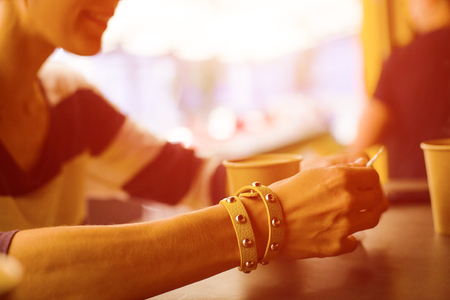 Friends relax in a cafe and drink hot drinks, coffee and tea are on the table.の写真素材