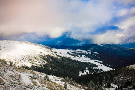 beautiful white clouds in the blue sky in winter mountains with snow.の写真素材