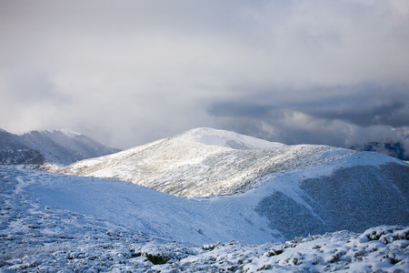 beautiful white clouds in the blue sky in winter mountains with snow.の写真素材