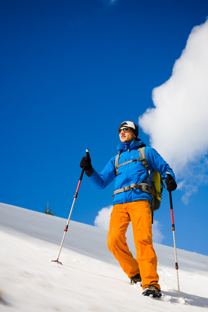 The climber is on a snowy hill during a winter hike.の写真素材