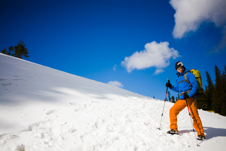 The climber is on a snowy hill during a winter hike.の写真素材