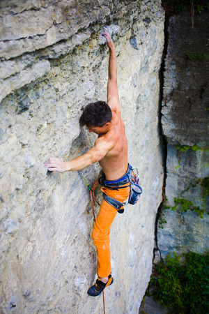 athletic man climbing the mountains, playing sports in nature.の写真素材