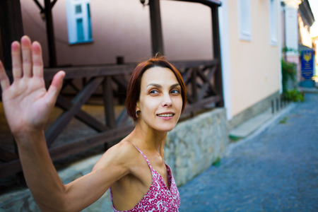 young woman on the street gives a high five and smiling, portrait of a girl.の写真素材