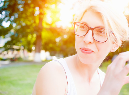 Portrait of a young woman with blond hair and stylish glasses.の写真素材