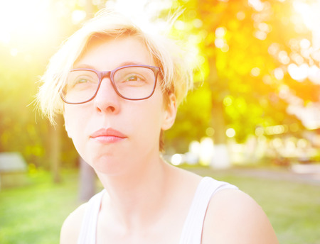 Portrait of a young woman with blond hair and stylish glasses, thoughtful girl.の写真素材