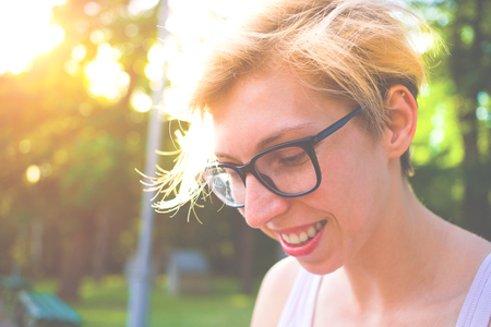 Portrait of a young woman with blond hair and stylish glasses, girl in glasses smiling.の写真素材