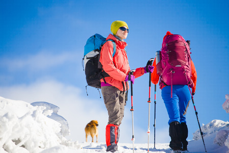 two girls are traveling with a dog in the mountains in winter, the snowy mountains during the winter holidays and mountaineering.
の写真素材
