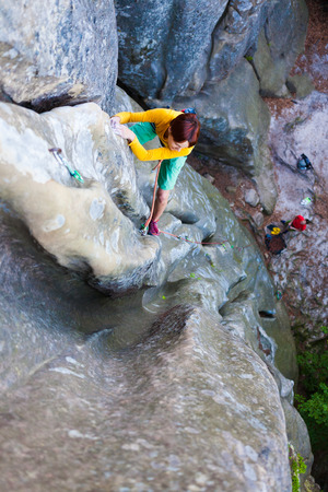 Sports girl climbs on the rock. Climbing in nature, active rest on a day off.の写真素材