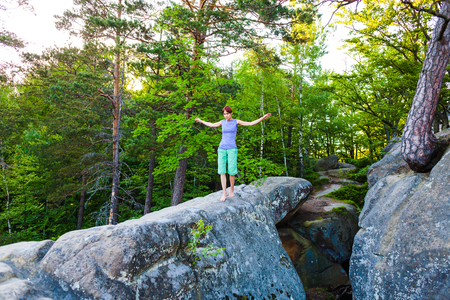 A young girl walks the stone to her goal. Balancing on a high stone.の写真素材