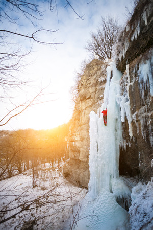 A young climber climbs on ice climbing and winter sport activities in cold weather.の写真素材