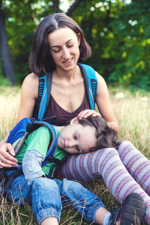 the boy lies with his mother in his arms while traveling through the forest and mountains with backpacks during the holidays. vacation in the forest with a small child. camping in the forest.
の写真素材
